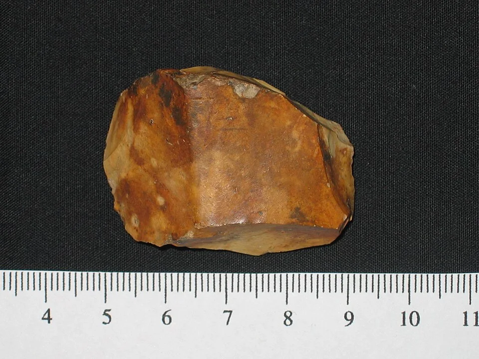 Stone axe fragment catalogued as Neolithic; a comparative illustration, not evidence from an identified Indian site.